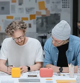 Two people reviewing sketches at a desk